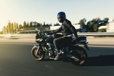 Motosiklet süren bir motosikletlinin yan görüntüsü otobanda hareket bulanıklığı olan bir sandalyede oturmak gibidir.. 