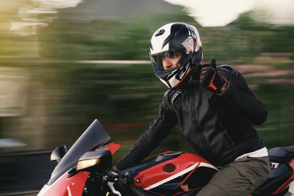 公路上骑红色摩托车的摩托车手的侧视图 动作模糊 — 图库照片