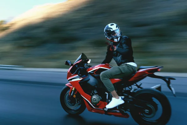公路上骑红色摩托车的摩托车手的侧视图 动作模糊 — 图库照片