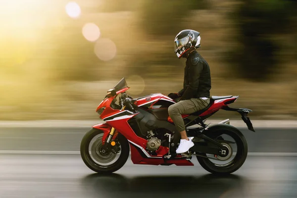 一个人骑着一辆没有人驾驶的红色赛车摩托车在高速公路上 — 图库照片