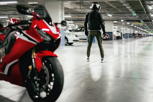 Widok Tyłu Motocyklisty Kasku Zdekoncentrowany Motocykl Wyścigowy Parkingu Samochodowym — Zdjęcie stockowe