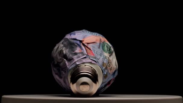 Lâmpada Embrulhada Com Notas 100 Dólares Girando Sobre Fundo Preto — Vídeo de Stock