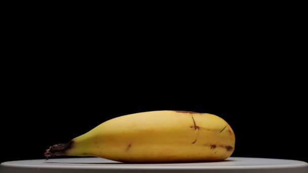 Banana Giratória Uma Plataforma Fundo Preto — Vídeo de Stock