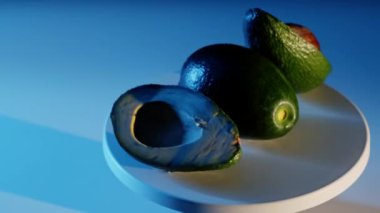 Dilimlenmiş Avokadoların koyu mavi bir arkaplan üzerinde dönüşünün görüntüsü.