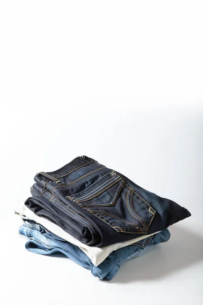 A pile of jeans on a white background.