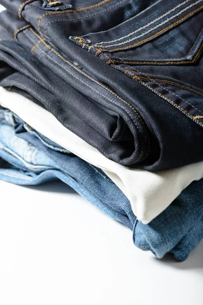 A pile of jeans on a white background.