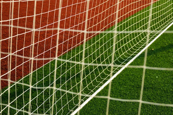 Close up shot of goal post with goal netting and goal line.