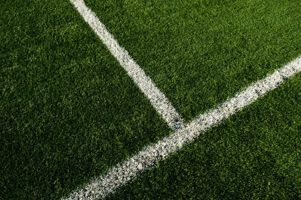 Close up shot of White lines at football pitch with artificial grass.