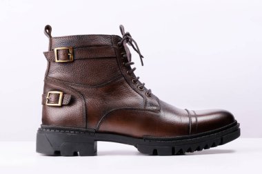 Beyaz arka planda kahverengi renkli deri bir botun yan görüntüsü.