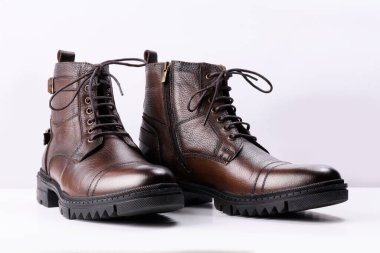 Beyaz arka planda kahverengi deri çizmeler..