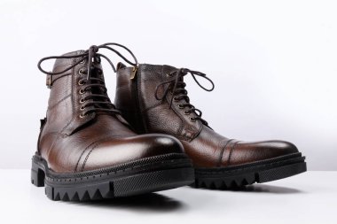 Beyaz arka planda kahverengi deri çizmeler..