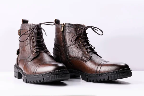 Beyaz arka planda kahverengi deri çizmeler..