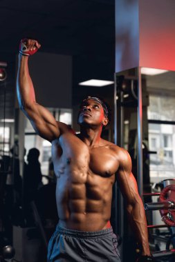 Spor salonunda yumruğu şişmiş kaslı bir zenci portresi.