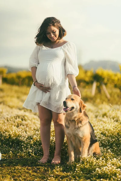 Usmívající Těhotná Žena Bílých Šatech Stojí Mezi Květinami Svou Dospělou — Stock fotografie