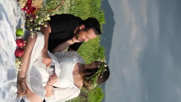 这对穿着白衣和黑衣的新婚夫妇在户外热吻了一下 这显示了他们在一次风景秀丽的野餐中的爱情纽带 — 图库视频影像