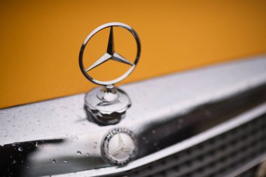 İzmir, Türkiye - 3 Haziran 2023: İzmir 'in Buca Pond kentinde düzenlenen IZKOD Klasik Araba Buluşması' nda sarı klasik Mercedes-Benz ambleminin yakın çekimi