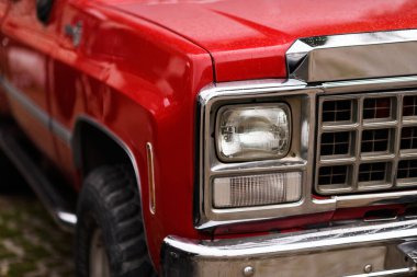 İzmir, Türkiye - 3 Haziran 2023: İzmir 'in Buca Pond kentinde düzenlenen IZKOD Klasik Otomobil Buluşması' nda 1980 model kırmızı bir Chevrolet Silverado kamyonunun yağmur damlacıklarıyla kaplı far görüntüsü
