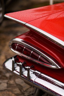 İzmir, Türkiye - 3 Haziran 2023: İzmir 'in Buca Pond kentinde düzenlenen IZKOD Klasik Otomobil Buluşması' nda 1957 model turuncu bir Chevrolet üzerindeki yağmur lekeli arka lambanın yakın çekimi.