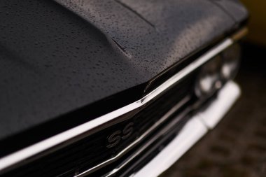 İzmir, Türkiye - 3 Haziran 2023: Yağmur damlalarıyla süslenmiş siyah bir Chevrolet Chevelle üzerindeki SS logosunun yakın çekimi