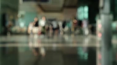 Havaalanının koşuşturma ve koşuşturmasını kaydeden odaklanmış bir video. Bavul taşıyan, yürüyen, bekleyen ve acele eden yolcuların siluetleri seyahatin rüya gibi ama dinamik atmosferini temsil ediyor.