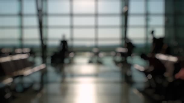 イズミル空港の搭乗ゲートの前で待っていると歩いている乗客の避難シルエット — ストック動画