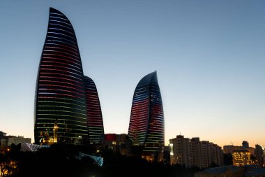 Bakü, Azerbaycan - 26 Haziran 2023: Azerbaycan bayrağının göz kamaştırıcı bir görüntüsüyle canlandırılan alaca karanlık bir fotoğraf. 