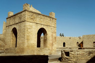 Bakü, Azerbaycan - 27 Haziran 2023: Ateshgah Tapınağı 'nın mimari bir fotoğrafı, Azerbaycan' daki tarihi bir ateş tapınağı, açık mavi bir gökyüzüne karşı. Benzersiz yapısı ve kültürel önemi ile bilinen tapınak, büyük bir turist olarak hizmet vermektedir.