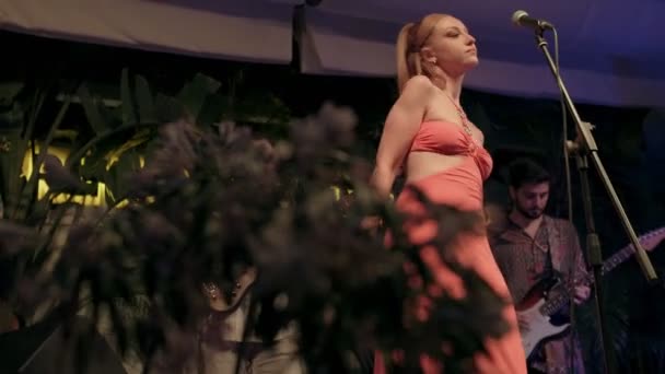 Μια Νεαρή Γυναίκα Γύρω Στα Είκοσι Ντυμένη Πορτοκαλί Φόρεμα Τραγουδάει — Αρχείο Βίντεο