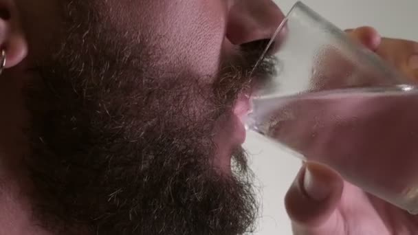 Man Met Gezichtshaar Drinkt Een Glas Koud Water Een Witte — Stockvideo