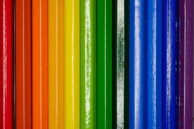 Renkli kalemlerin bir fotoğrafı sıralanmış, görünmeden bitiyor, canlı renklerin ve çeşitliliğin sürekli akışını sergiliyor..