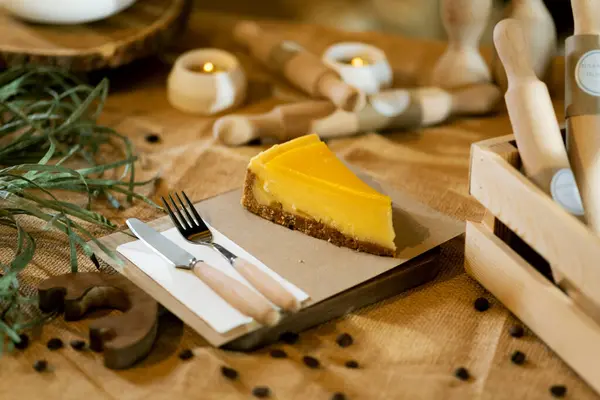 Slice Orange Cheesecake Sits Wooden Board Burlap Tablecloth Wooden Handled — Stock Photo, Image