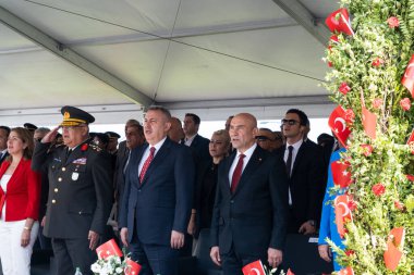 İzmir, Türkiye, 9 Eylül 2023 İzmir Kurtuluş Günü 'nü kutlayan bir insan denizinin ortasında Mustafa Kemal Atatrk' ın fonda çarpıcı bir günbatımının portresini taşıyan bir Türk bayrağını tutkuyla sallayan tek bir kişi görülüyor.