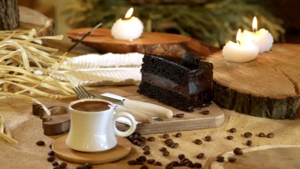 木製のカトラリーの隣にチョコレートケーキのスライスを展示するビデオ 伝統的なトルコのコーヒーを伴う すべての暖かく設定 背景を招待 — ストック動画