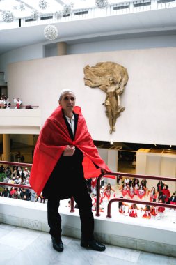 Tiran, Arnavutluk - 28 Kasım: Arnavutluk bayrağına sarılmış bir adam, kutlamalar sırasında Rahibe Teresa heykelinin yanında duruyor