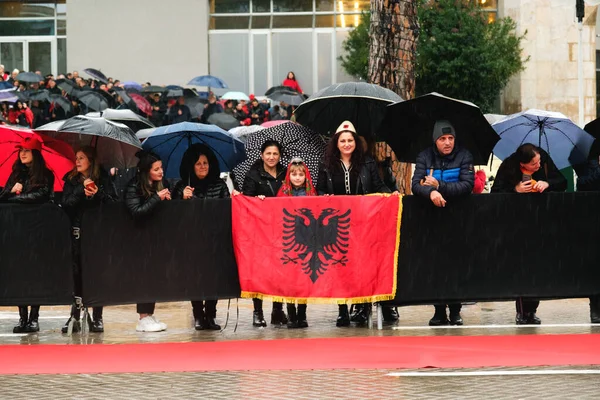 ティラナ アルバニア 11月 2023 雨の独立記念日に アルバニアの旗と傘を持つ市民は 国家の殉教者の大通りの道で道端からパレードを見ます — ストック写真