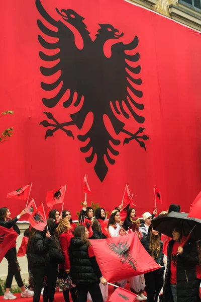 ティラナ アルバニア 2023年11月28日 雨の日 ティラナ市庁舎は巨大なアルバニアの旗で覆われています 市民は旗を掲げた建物を通過し 笑顔で喜んで行進し アルバニアの旗を掲げている — ストック写真