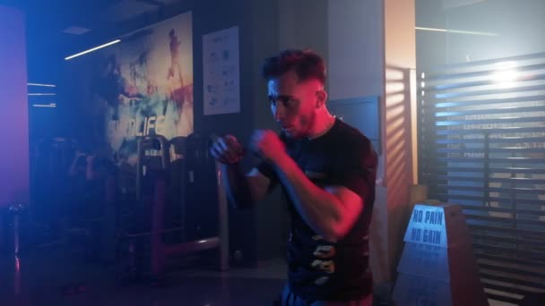 Male Athlete Engages Shadow Boxing Perfecting His Kickboxing Skills Dimly — Stock Video