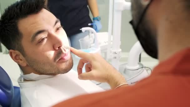 Een Patiënt Communiceert Zijn Tandheelkundige Problemen Met Tandarts Tijdens Een — Stockvideo