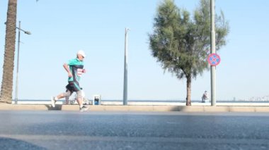 İzmir, Türkiye - 10 Eylül 2023: İzmir 'in manzaralı kıyı şeridine karşı düzenlenen yıllık 9 Eylül Yarısı Maratonu sırasında koşucuların ayaklarının yavaş çekimde yakın plan çekimleri ile rekabet heyecanı yakalanıyor