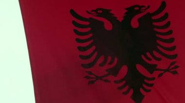 Arnavutluk bayrağı, ulusal gurur ve mirasın bir simgesi olan geniş ve bulutlarla dolu gökyüzünün zemininde zarifçe dalgalanıyor