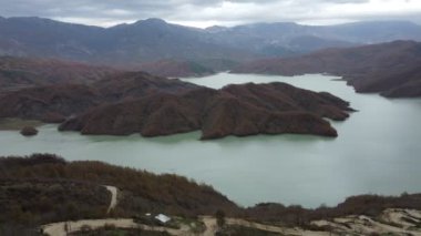 Bovilla Gölü 'nün sakin sularının havadan görünüşü, insansız hava aracı tarafından yakalanan Tiran dağları arasında yer alıyor.