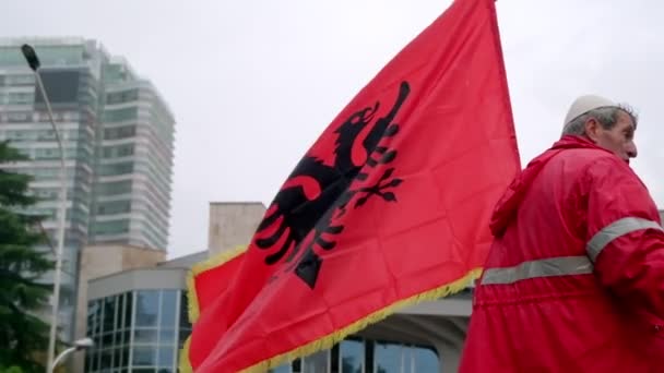 アルバニアのティラナ 2023年11月28日 伝統的なドレスの高齢者は マザーテレサ宮殿の近くで独立記念日の祝賀会中にアルバニアの旗を保持しながらインタビューを行います — ストック動画