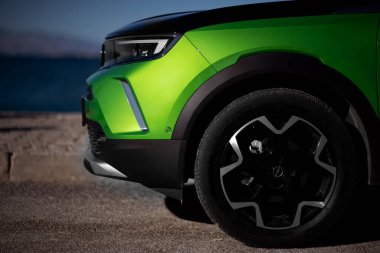 İzmir, Türkiye - 23 Aralık 2023: Yeşil bir 2022 Opel Mokka 'nın ön planının yakın plan çekimi, modelin tasarım ve özelliklerini bir dış fona karşı sergiliyor