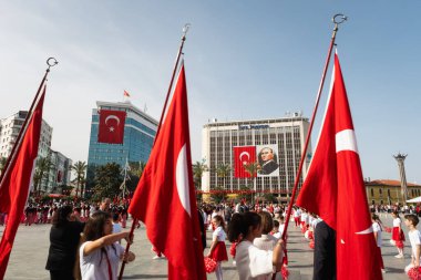 İzmir, Türkiye - 23 Nisan 2024: İzmir Cumhuriyet Meydanı 'nda, ellerinde Türk bayrakları bulunan çocuklar 23 Nisan 2024' te düzenlenen festival kutlamaları sırasında Ulusal Egemenlik ve Çocuk Günü geçit töreninin başlamasını bekliyorlar.