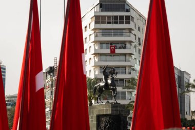 İzmir, Türkiye - 23 Nisan 2024: İzmir 'de düzenlenen Ulusal Egemenlik ve Çocuk Günü kutlamaları sırasında, Türk bayrakları tarafından çerçevelenen Atatürk' ün binicilik heykeli Cumhuriyet Meydanı 'nda gururla duruyor