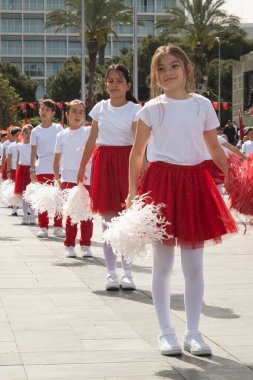 İzmir, Türkiye - 23 Nisan 2024: Türkiye 'nin Ulusal Egemenlik ve Çocuk Günü kutlamaları sırasında Cumhuriyet Meydanı' nda kırmızı ve beyaz giyinmiş çocuklar ponpon kızlarıyla neşeyle dans ediyorlar