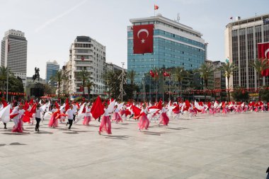 İzmir, Türkiye - 23 Nisan 2024: Türkiye 'nin Ulusal Egemenlik ve Çocuk Günü kutlamaları sırasında İzmir Cumhuriyet Meydanı' nda kırmızı ve beyaz giyinmiş genç kız öğrenciler bayrak dansı yaptılar