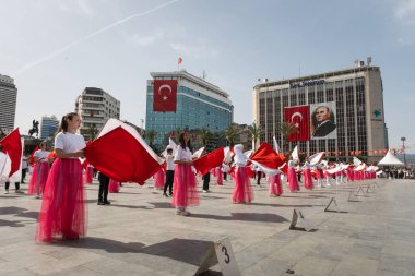 İzmir, Türkiye - 23 Nisan 2024: Türkiye 'nin Ulusal Egemenlik ve Çocuk Günü kutlamaları sırasında İzmir Cumhuriyet Meydanı' nda kırmızı ve beyaz giyinmiş genç kız öğrenciler bayrak dansı yaptılar