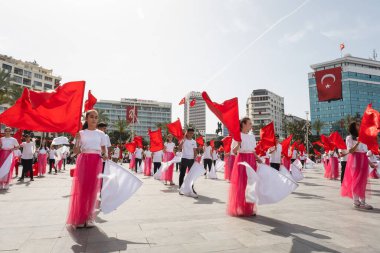 İzmir, Türkiye - 23 Nisan 2024: Kırmızılı ve beyazlı genç öğrenciler, Türkiye 'nin Ulusal Egemenlik ve Çocuk Günü kutlamaları sırasında İzmir Cumhuriyet Meydanı' nda bayrak dansı yaptılar