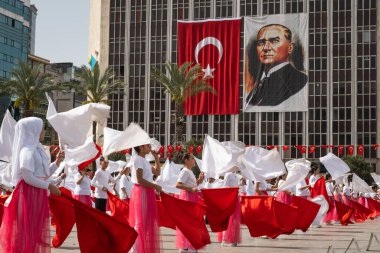 İzmir, Türkiye - 23 Nisan 2024: Türkiye 'nin Ulusal Egemenlik ve Çocuk Günü kutlamaları sırasında İzmir Cumhuriyet Meydanı' nda kırmızı ve beyaz giyinmiş genç kız öğrenciler bayrak dansı yaptılar